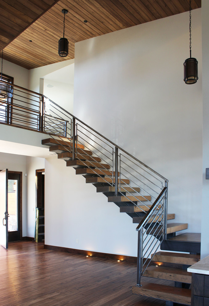 Exemple d'un escalier sans contremarche tendance en L avec des marches en bois, un garde-corps en métal et éclairage.