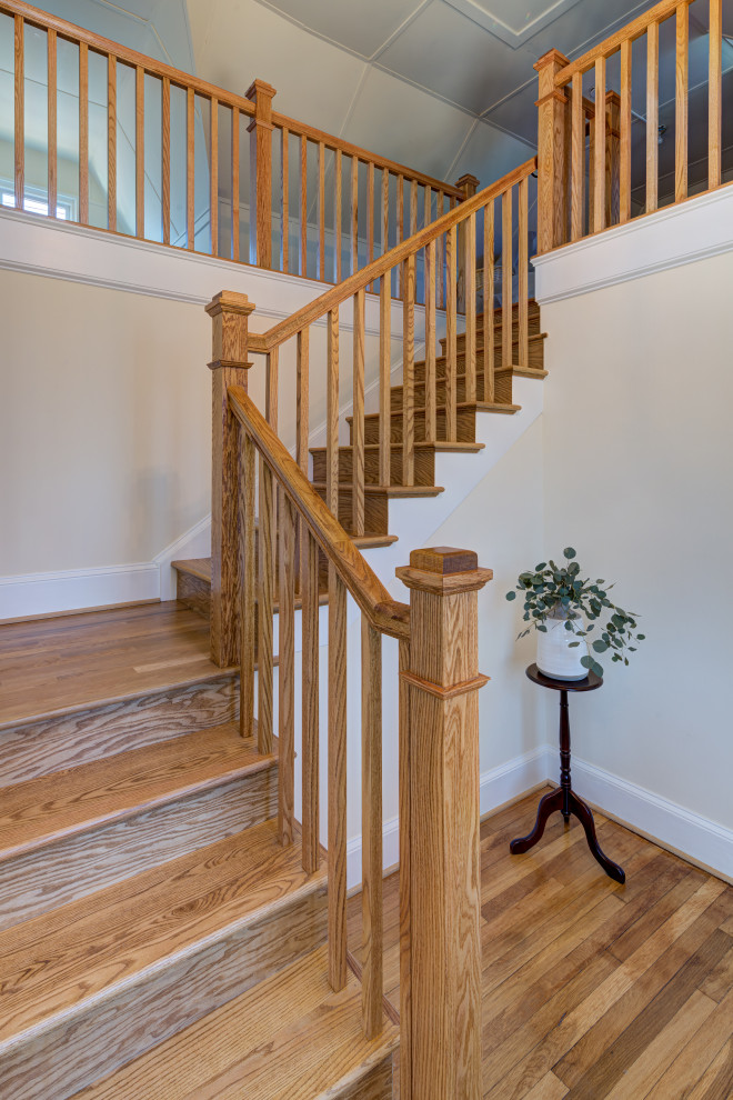 Imagen de escalera en L clásica grande con escalones de madera, contrahuellas de madera y barandilla de madera