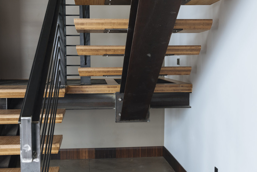 На фото: п-образная лестница среднего размера в стиле модернизм с деревянными ступенями и металлическими перилами без подступенок с