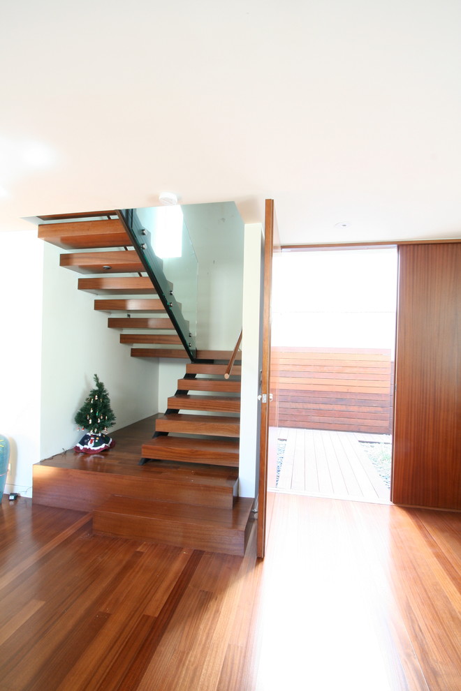 Design ideas for a small modern wood u-shaped staircase in Los Angeles with open risers.