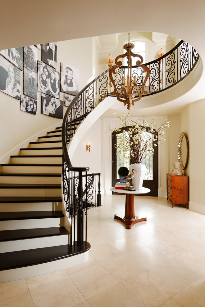 Свежая идея для дизайна: огромная изогнутая лестница в классическом стиле с деревянными ступенями - отличное фото интерьера