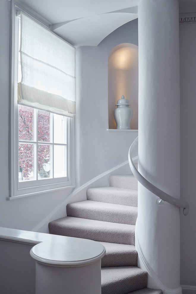 Imagen de escalera curva, clásica renovada, con escalones enmoquetados, contrahuellas enmoquetadas y barandilla de madera