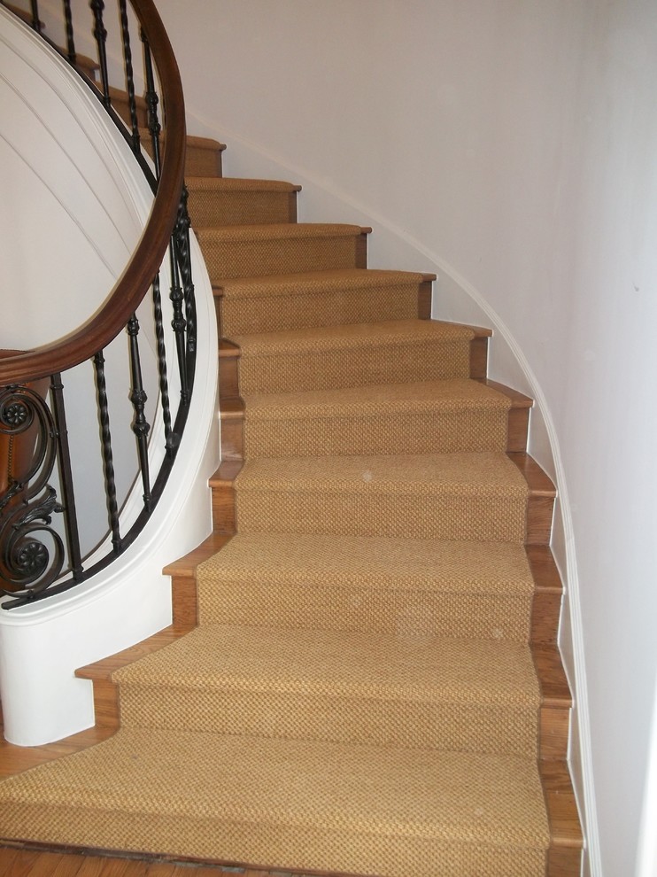 Diseño de escalera curva tradicional de tamaño medio con escalones de madera y contrahuellas de madera