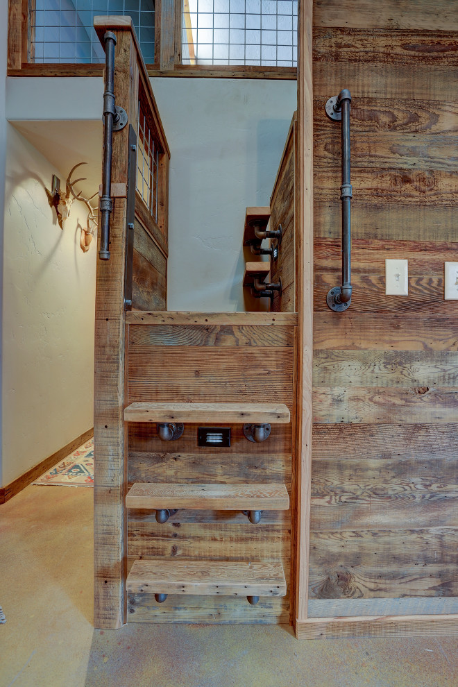 На фото: маленькая угловая металлическая лестница в стиле рустика с деревянными ступенями и металлическими перилами для на участке и в саду