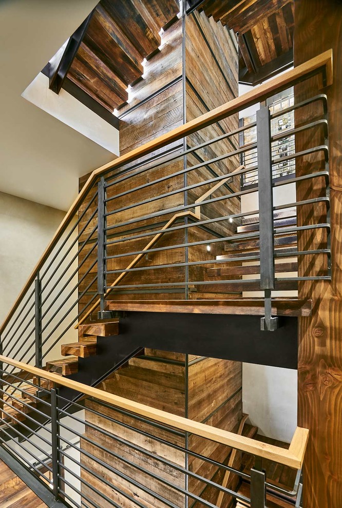 На фото: п-образная лестница в стиле рустика с деревянными ступенями и металлическими перилами с