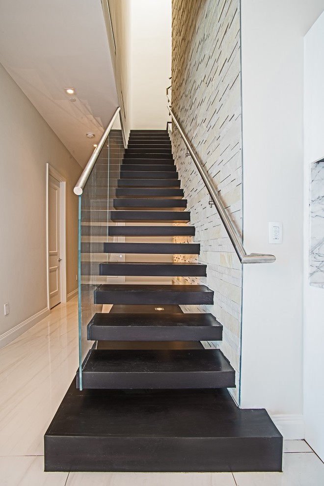Cette photo montre un escalier sans contremarche droit tendance de taille moyenne avec des marches en bois et un garde-corps en verre.