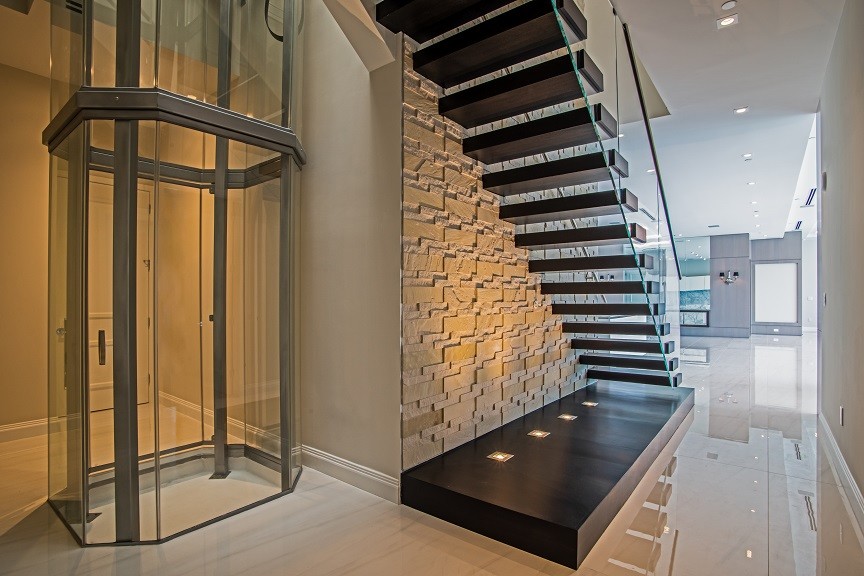 На фото: прямая лестница среднего размера в современном стиле с деревянными ступенями и стеклянными перилами без подступенок
