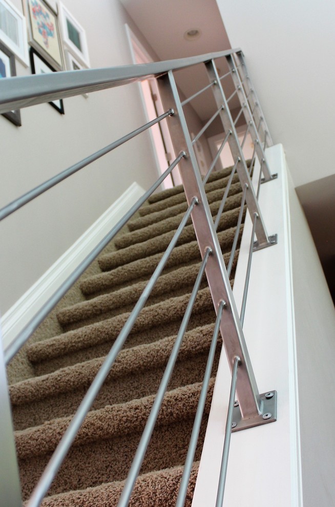 На фото: прямая лестница среднего размера в современном стиле с ступенями с ковровым покрытием, ковровыми подступенками и металлическими перилами с