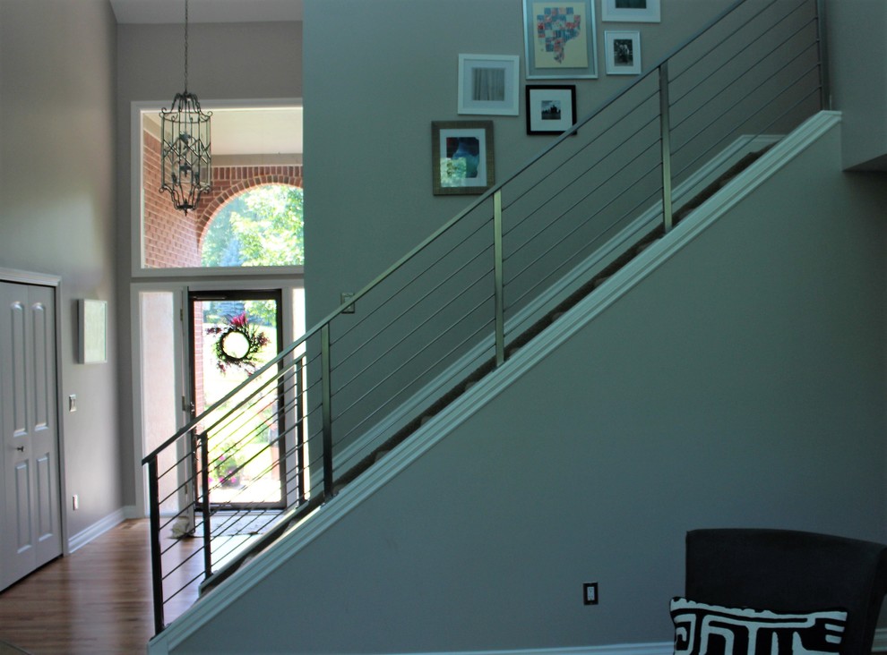 Foto på en mellanstor funkis rak trappa, med heltäckningsmatta, sättsteg med heltäckningsmatta och räcke i metall