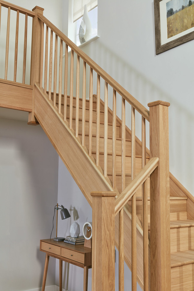 Photo of a large contemporary wood u-shaped wood railing staircase in Manchester with wood risers.