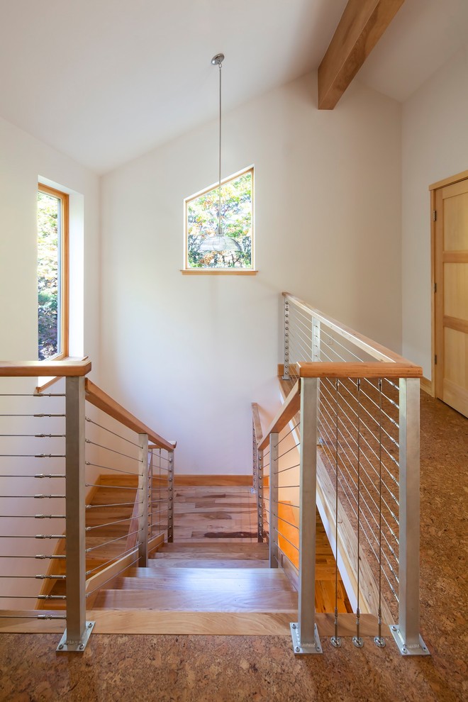Imagen de escalera en U actual de tamaño medio con escalones de madera, contrahuellas de madera y barandilla de varios materiales
