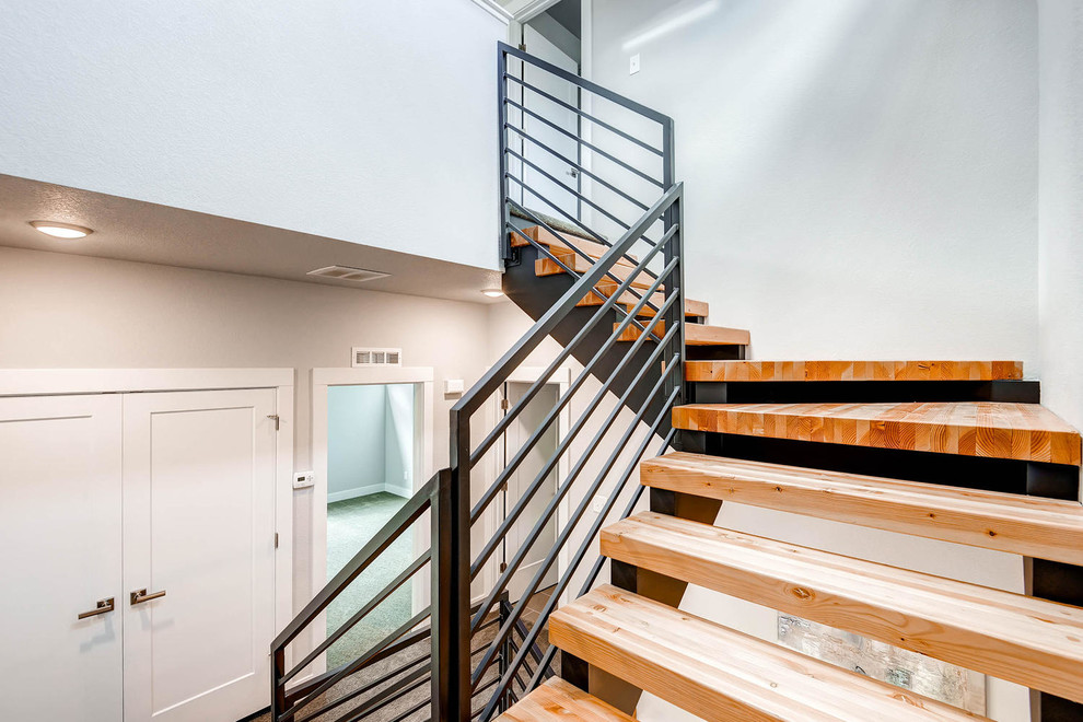 Idées déco pour un grand escalier sans contremarche hélicoïdal contemporain avec des marches en bois et un garde-corps en métal.