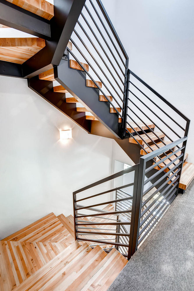Пример оригинального дизайна: большая винтовая деревянная лестница в современном стиле с деревянными ступенями и металлическими перилами