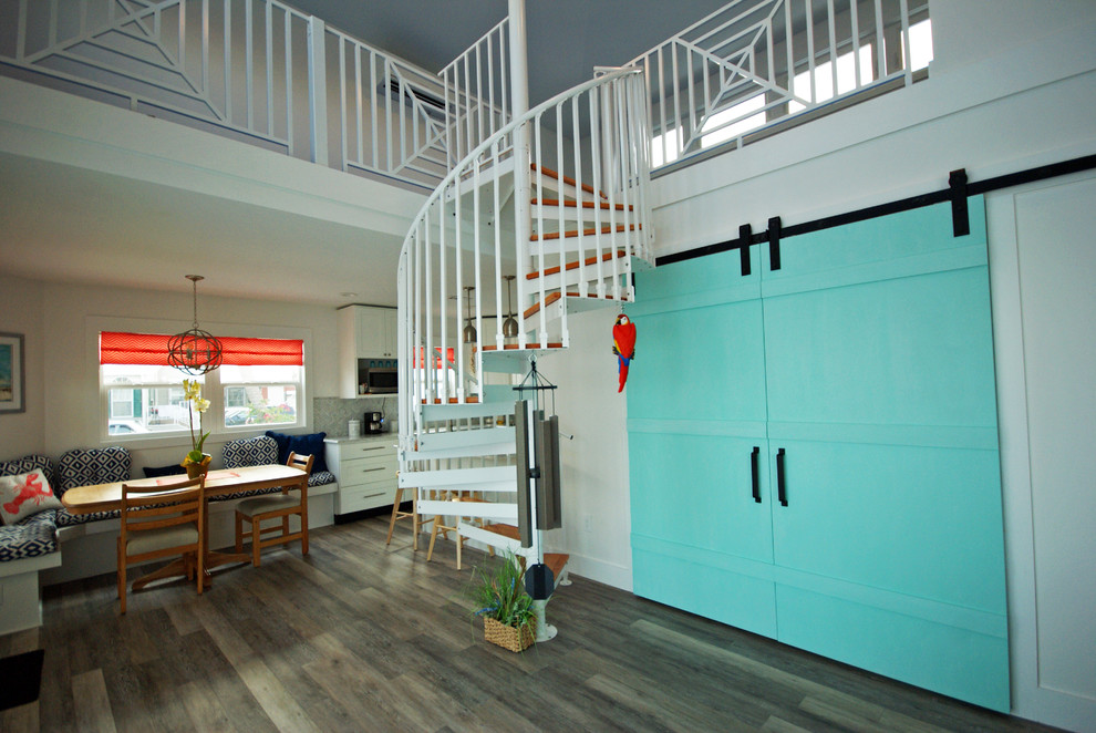 Example of a small beach style wooden spiral staircase design in Miami with metal risers