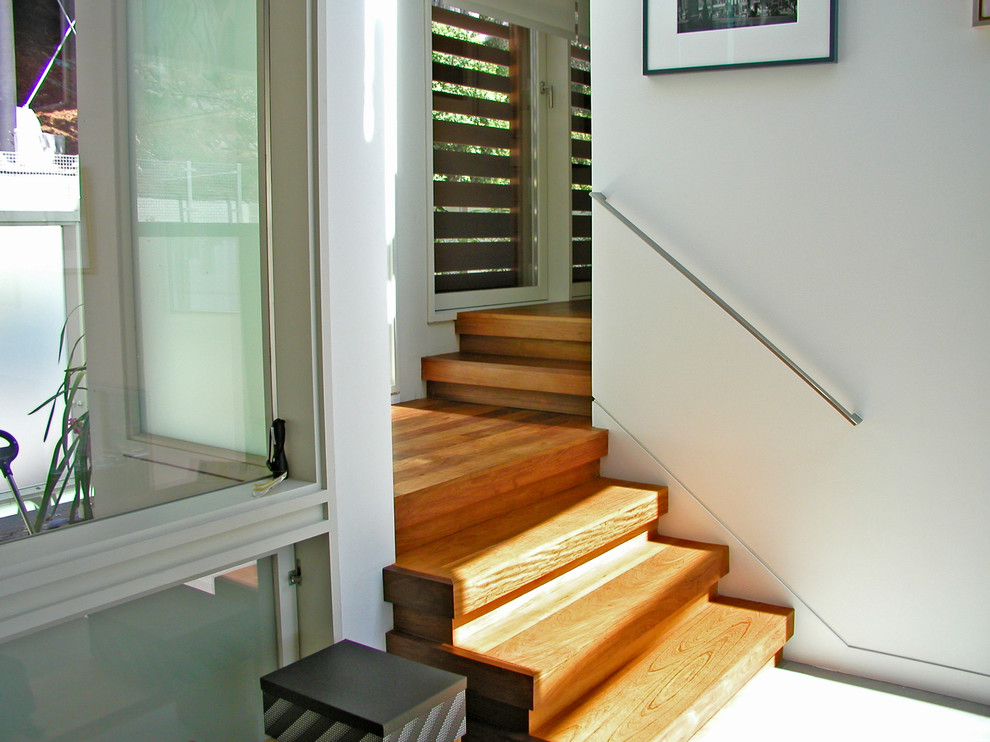 Foto de escalera en L actual de tamaño medio con escalones de madera y contrahuellas de madera