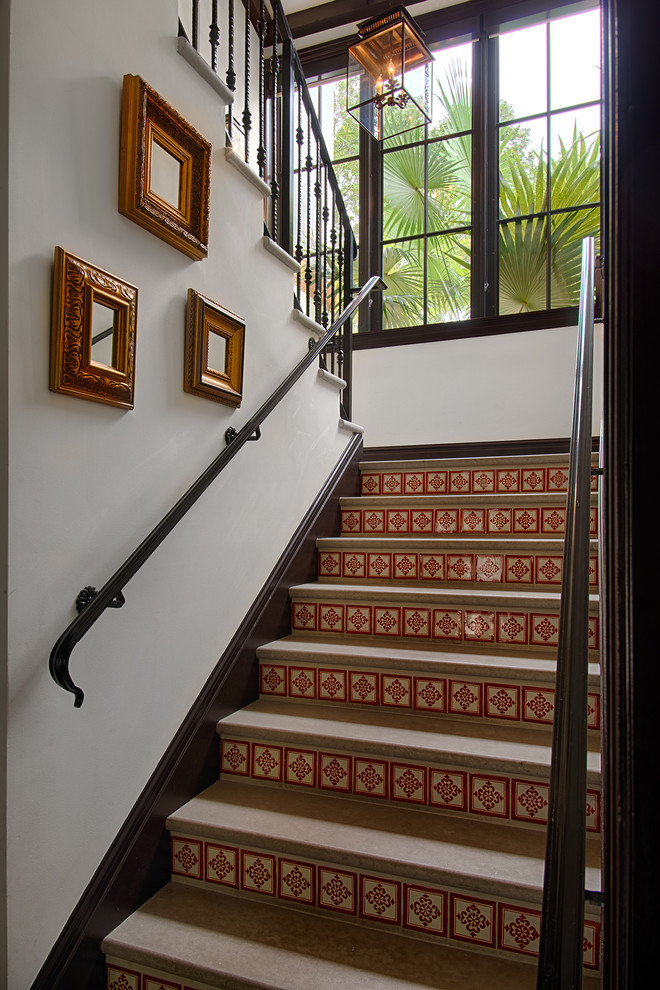 Foto de escalera en U tropical de tamaño medio con contrahuellas con baldosas y/o azulejos