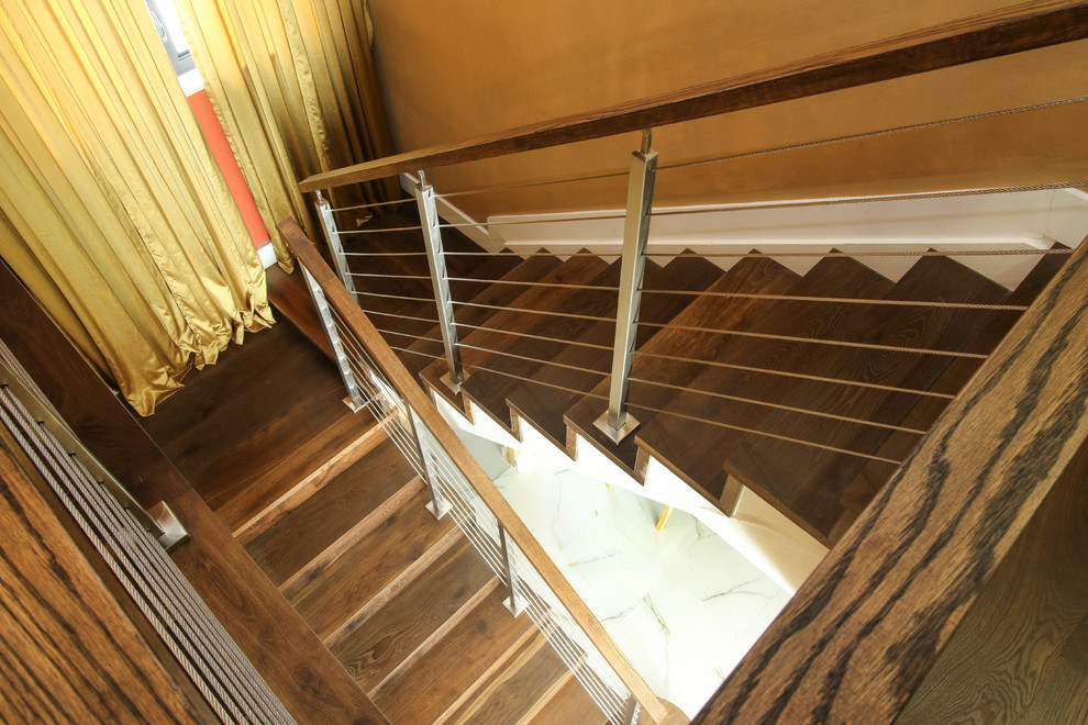 Ejemplo de escalera en U actual de tamaño medio con escalones de madera y contrahuellas de madera