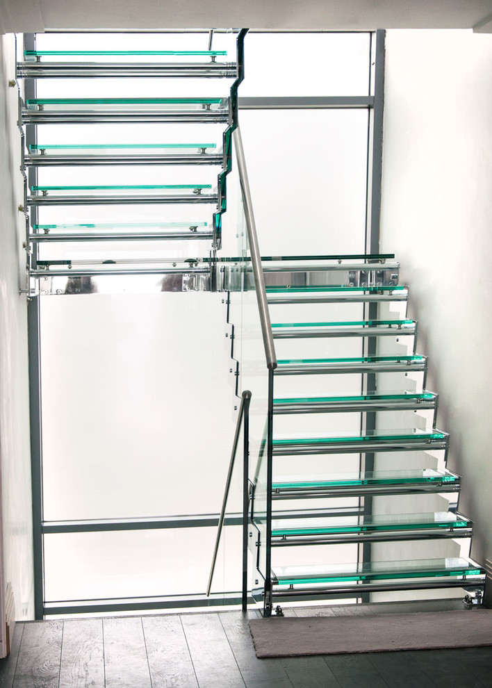 Imagen de escalera recta contemporánea de tamaño medio con escalones de vidrio, contrahuellas de metal y barandilla de varios materiales