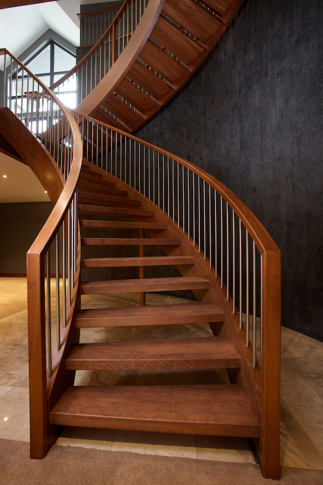 Ejemplo de escalera curva contemporánea sin contrahuella con escalones de madera