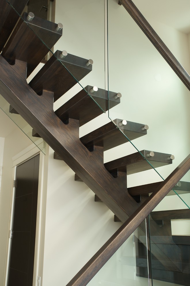 Design ideas for a modern wood floating glass railing staircase in Edmonton with open risers.