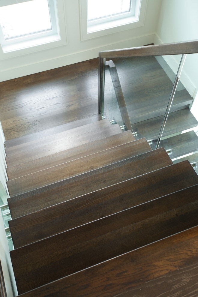 Inspiration for a modern wooden floating open and glass railing staircase remodel in Edmonton