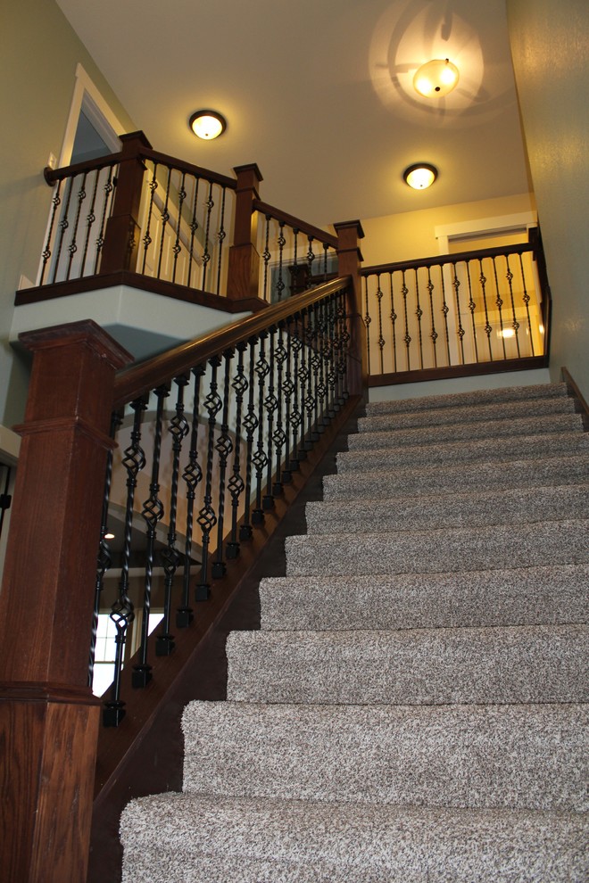 Idée de décoration pour un escalier tradition en L de taille moyenne avec des marches en moquette, des contremarches en moquette, un garde-corps en bois et éclairage.