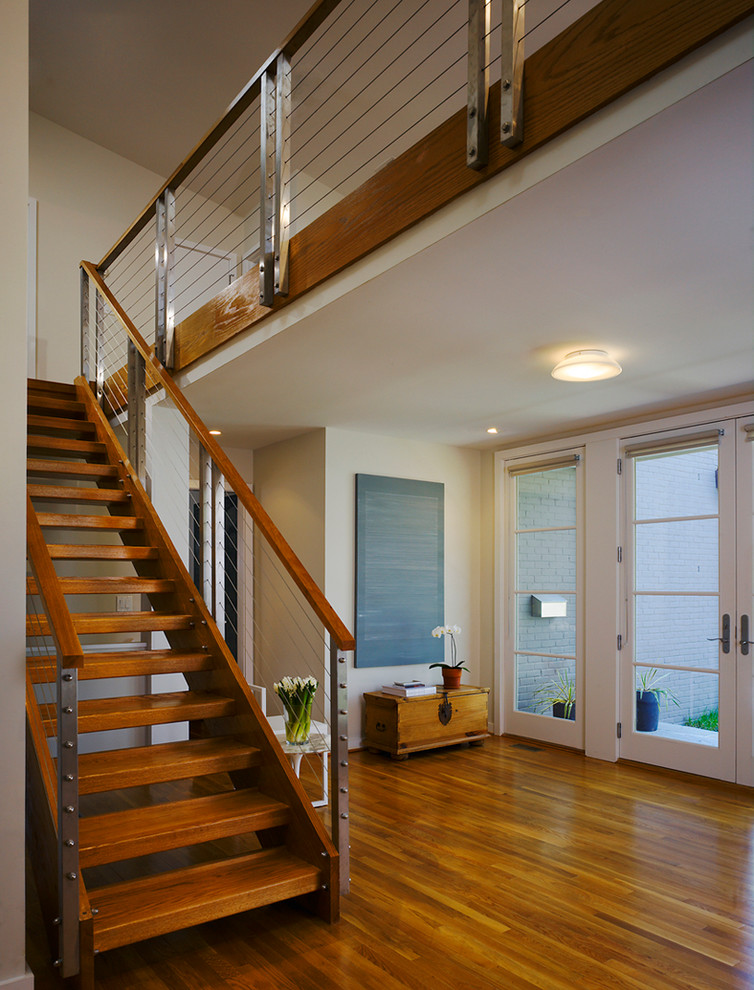 Diseño de escalera actual sin contrahuella con escalones de madera y barandilla de cable