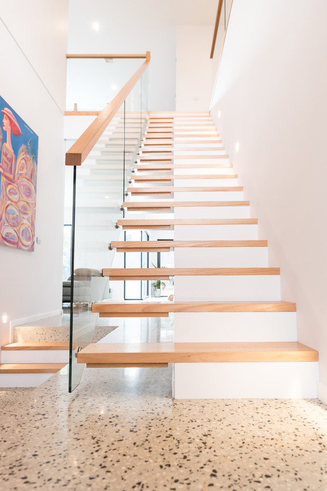 Modelo de escalera recta contemporánea grande con escalones de madera y barandilla de vidrio