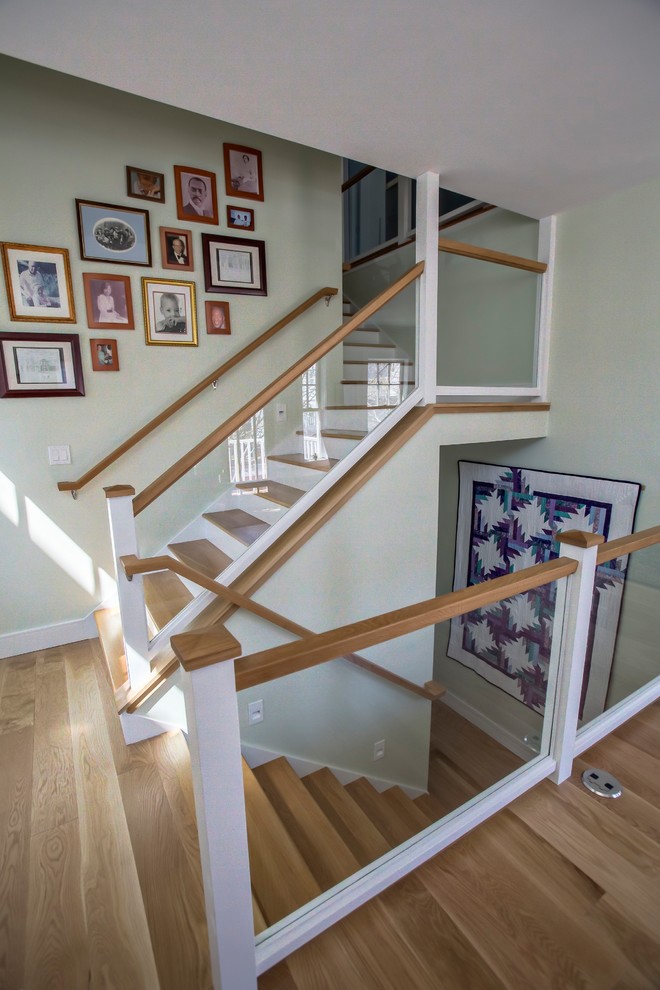 Пример оригинального дизайна: угловая лестница среднего размера в стиле неоклассика (современная классика) с деревянными ступенями, крашенными деревянными подступенками и стеклянными перилами