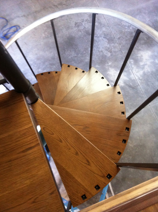 Свежая идея для дизайна: изогнутая лестница среднего размера в стиле лофт с деревянными ступенями без подступенок - отличное фото интерьера