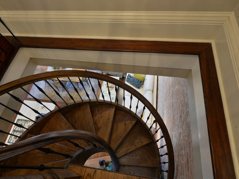 Cette photo montre un petit escalier hélicoïdal chic avec des marches en bois et des contremarches en bois.