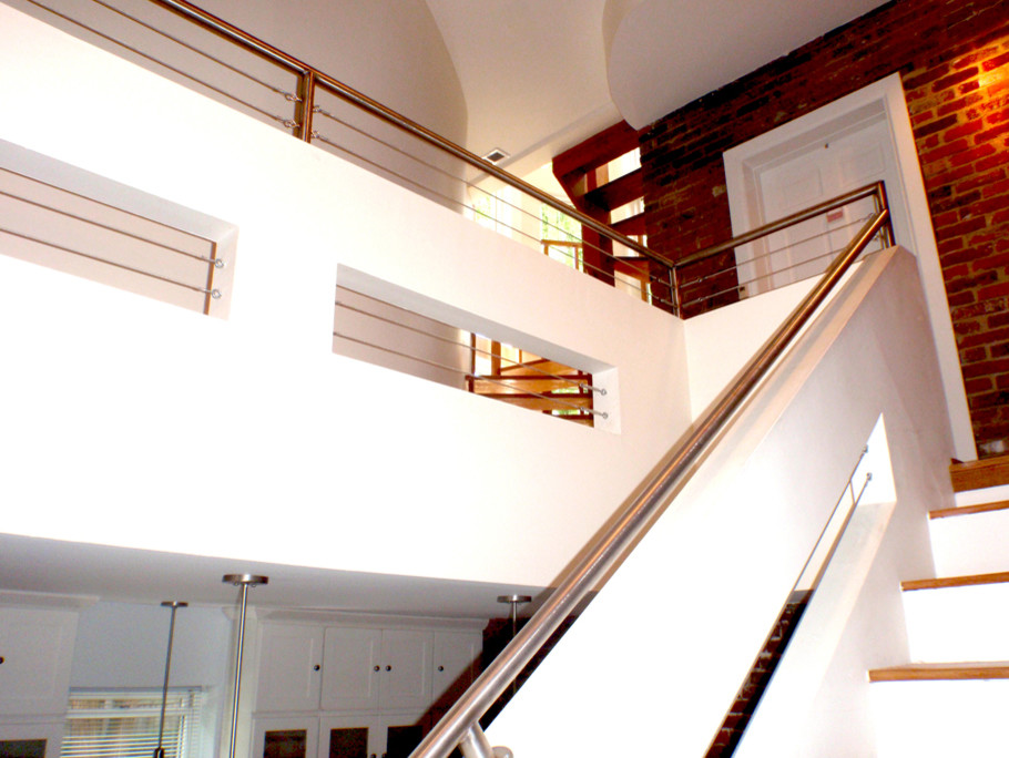 Diseño de escalera recta minimalista de tamaño medio con escalones de madera y contrahuellas de madera pintada