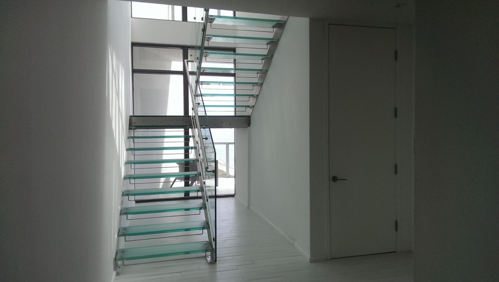 Design ideas for a medium sized modern glass straight glass railing staircase in Tampa with open risers.