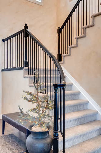 Diseño de escalera en U tradicional de tamaño medio con escalones enmoquetados, contrahuellas enmoquetadas y barandilla de madera