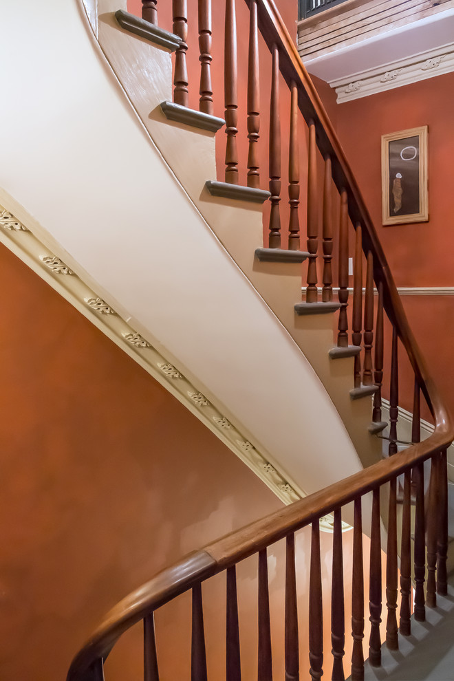 На фото: лестница в стиле фьюжн с деревянными перилами с