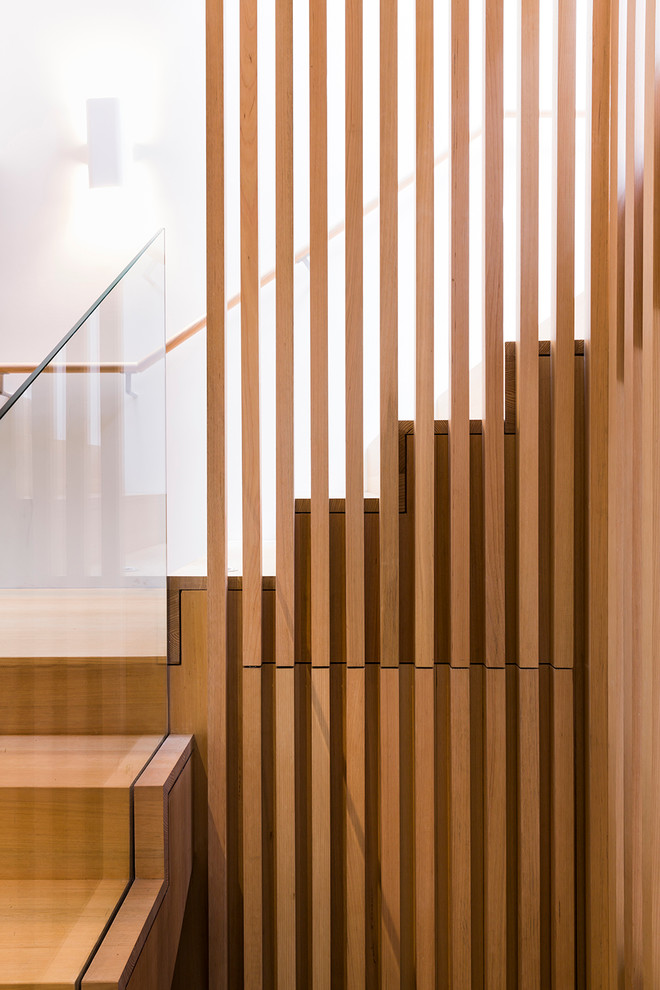 Aménagement d'un escalier contemporain en U de taille moyenne avec des marches en bois, des contremarches en bois et éclairage.