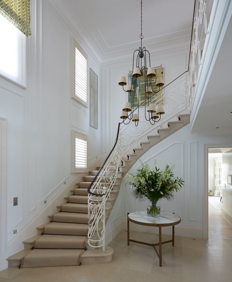 Inspiration pour un grand escalier courbe traditionnel avec des marches en moquette et éclairage.