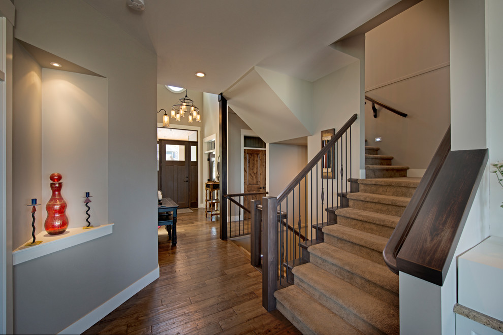 На фото: п-образная лестница среднего размера в стиле кантри с ступенями с ковровым покрытием и ковровыми подступенками