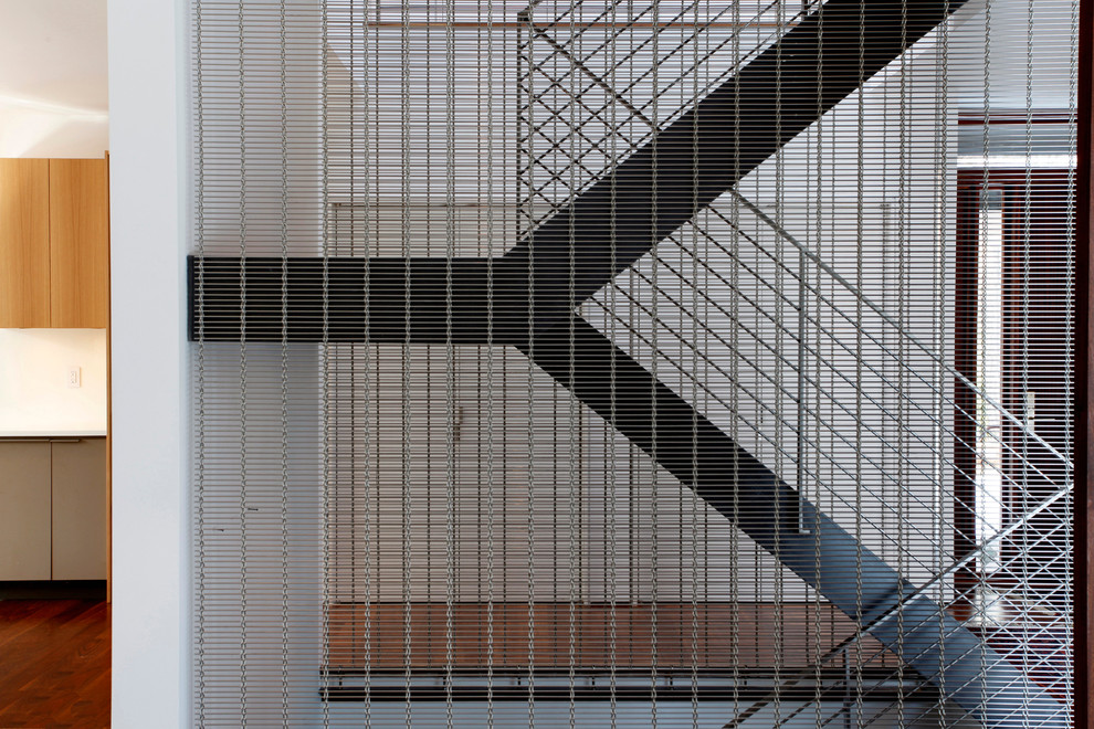 Diseño de escalera en U contemporánea de tamaño medio sin contrahuella con barandilla de metal y escalones de madera