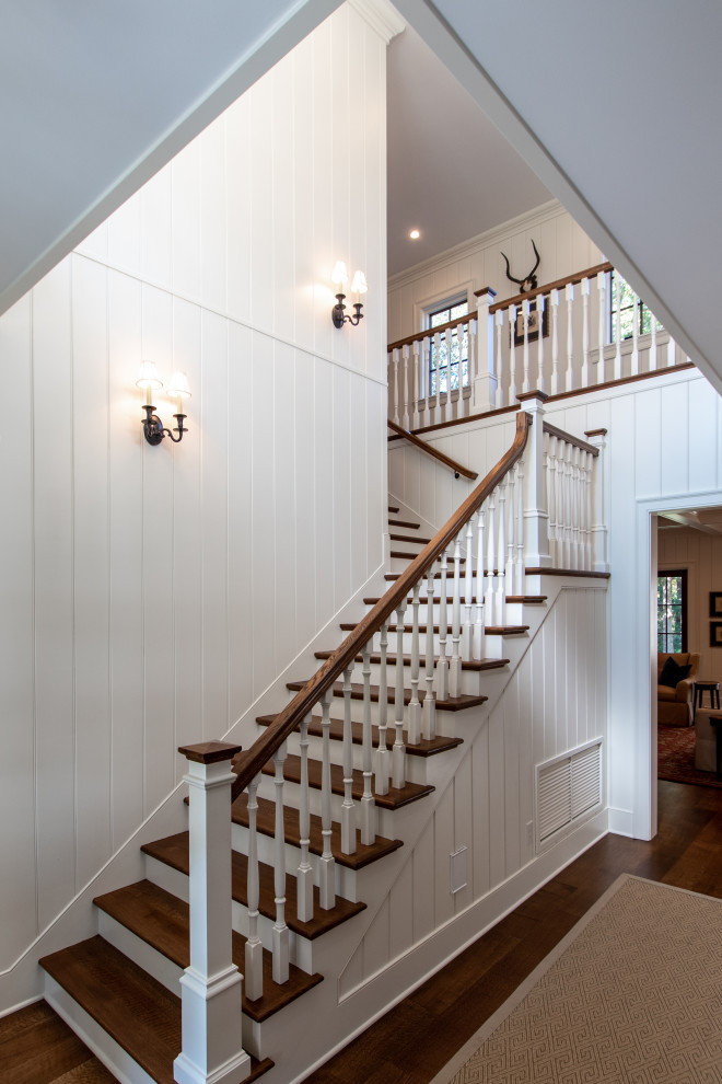 Large farmhouse wood l-shaped wood railing staircase in Other with painted wood risers.