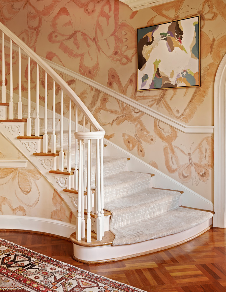 Пример оригинального дизайна: изогнутая лестница в классическом стиле с деревянными ступенями и крашенными деревянными подступенками
