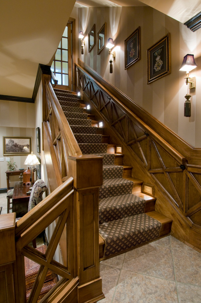 На фото: большая угловая деревянная лестница в классическом стиле с деревянными ступенями и деревянными перилами с