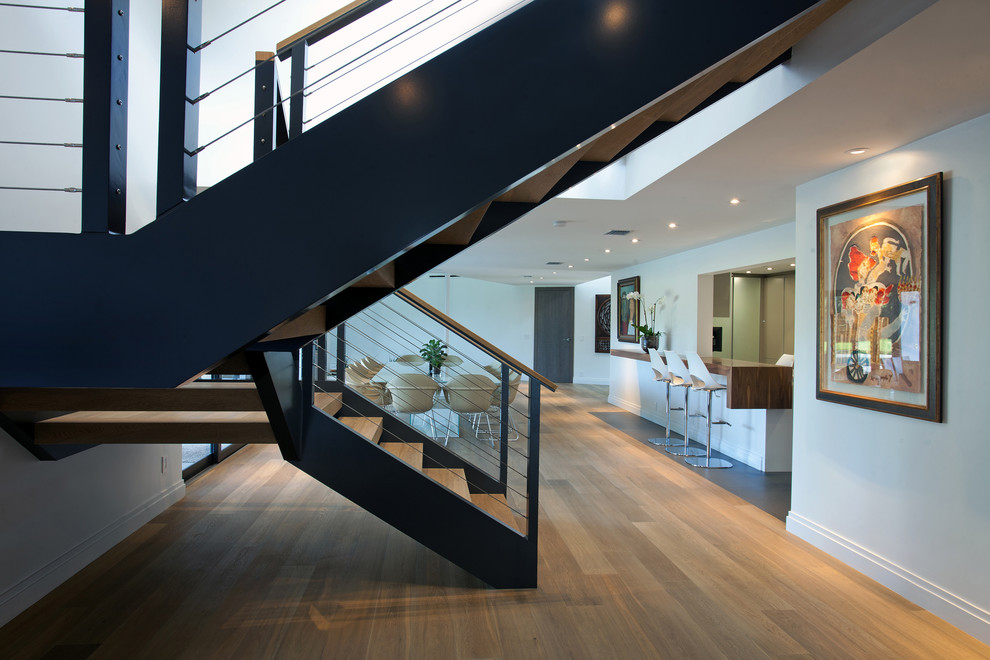 Пример оригинального дизайна: изогнутая лестница среднего размера в современном стиле с деревянными ступенями и металлическими перилами