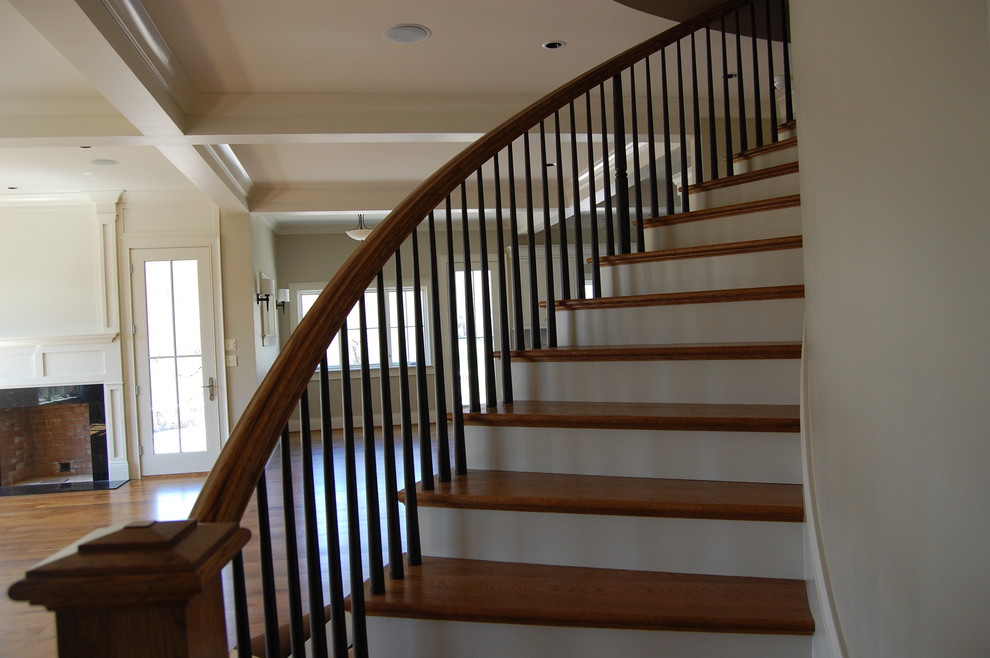 Imagen de escalera curva de estilo americano de tamaño medio con escalones de madera y contrahuellas de madera pintada