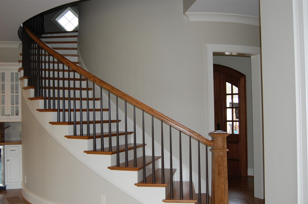 Пример оригинального дизайна: изогнутая лестница среднего размера в стиле кантри с деревянными ступенями и крашенными деревянными подступенками