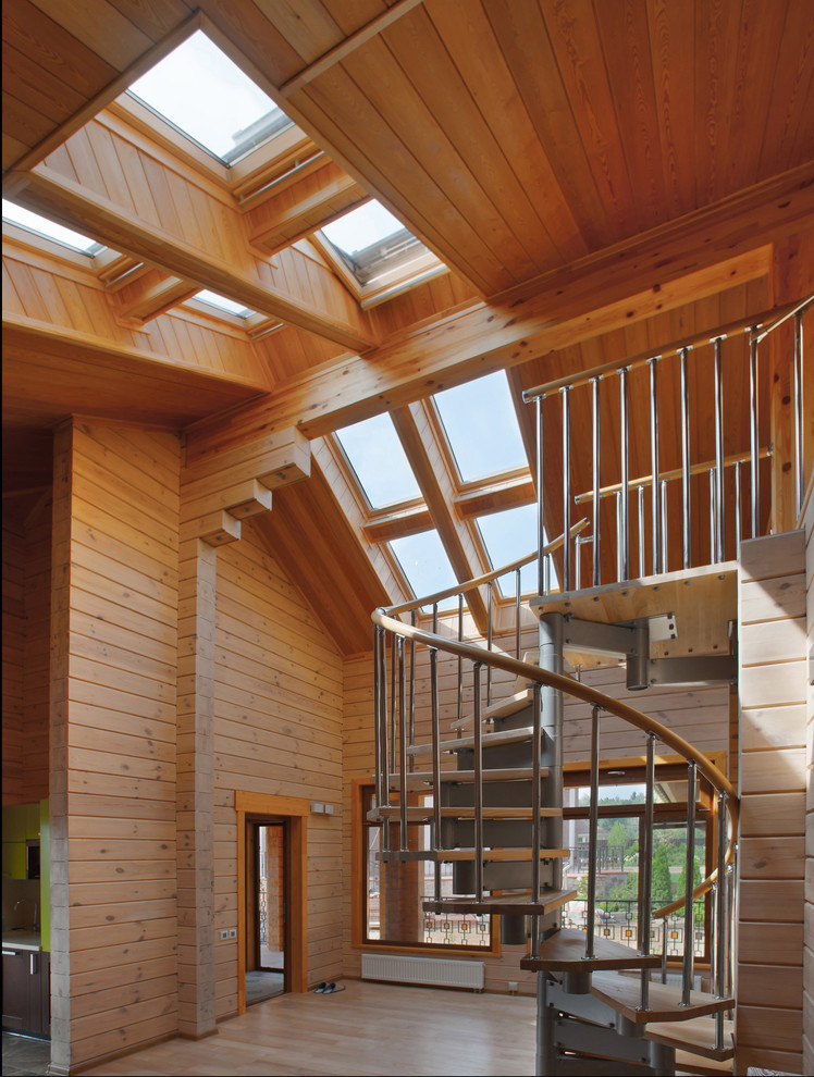 На фото: винтовая деревянная лестница среднего размера в современном стиле с металлическими ступенями с