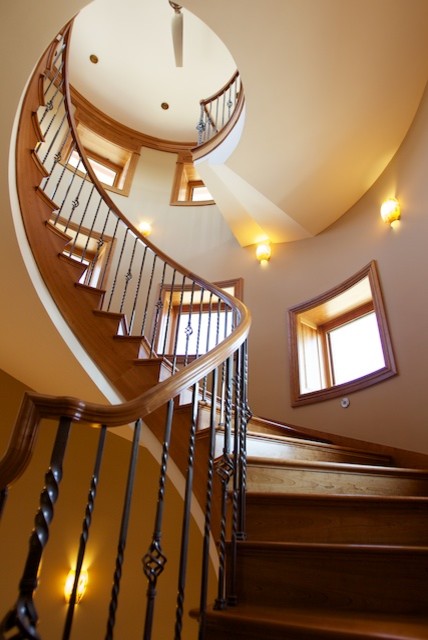 Aménagement d'un grand escalier hélicoïdal classique avec des marches en bois et des contremarches en bois.