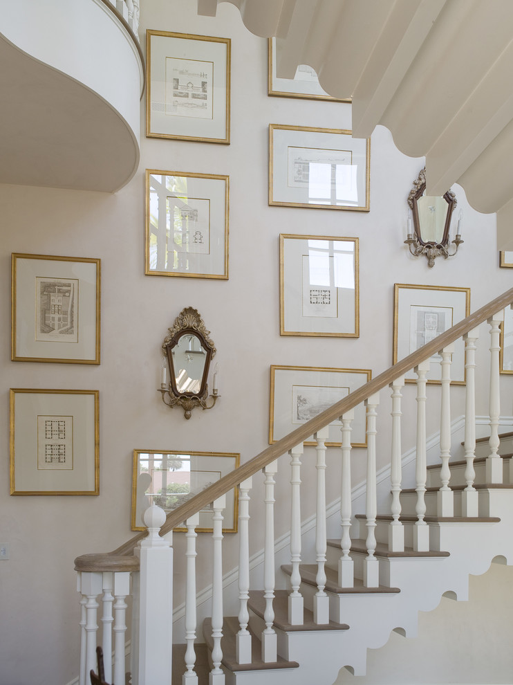 На фото: большая п-образная лестница в классическом стиле с деревянными ступенями и крашенными деревянными подступенками