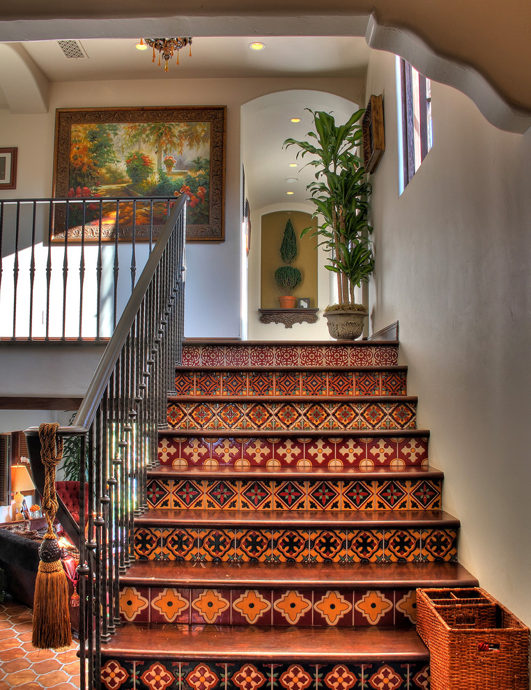 Staircase - southwestern wooden metal railing staircase idea in Los Angeles with tile risers