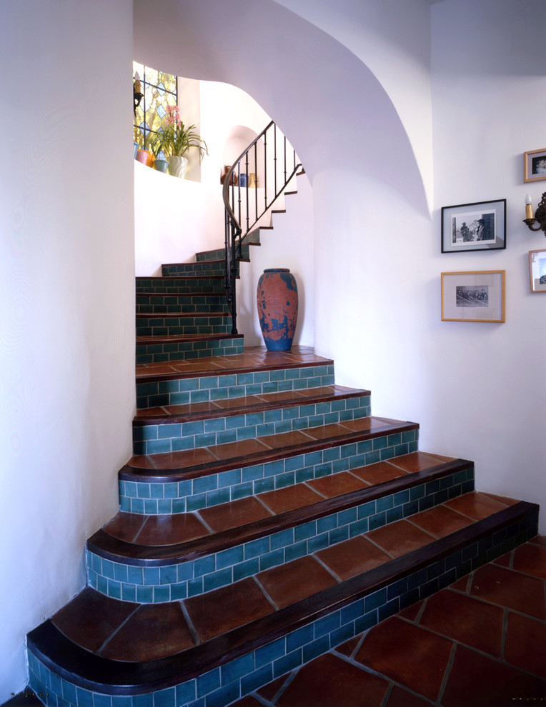 Стильный дизайн: лестница в средиземноморском стиле с подступенками из плитки, ступенями из терракотовой плитки и металлическими перилами - последний тренд